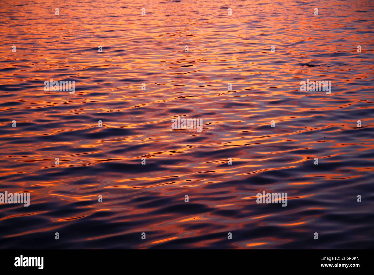 The beauty of the colors of the waves in the water during a summer sunset with a close up shot Stock Photo
