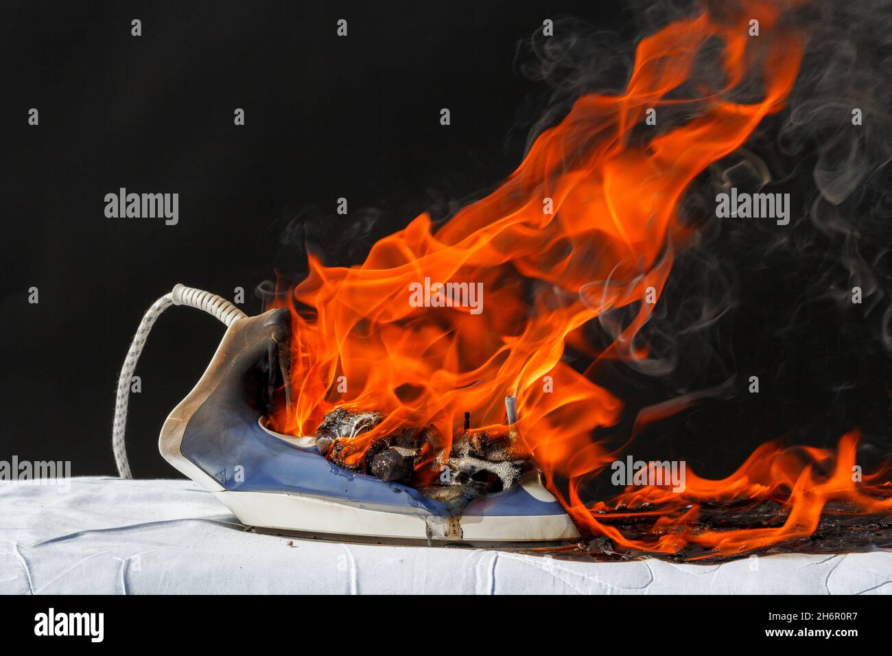 Iron on ironing board in flames fire, cause of fire Stock Photo Alamy