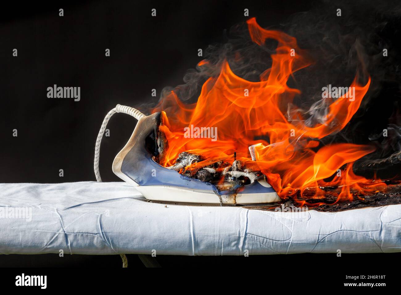 Iron on ironing board in flames fire, cause of fire Stock Photo Alamy