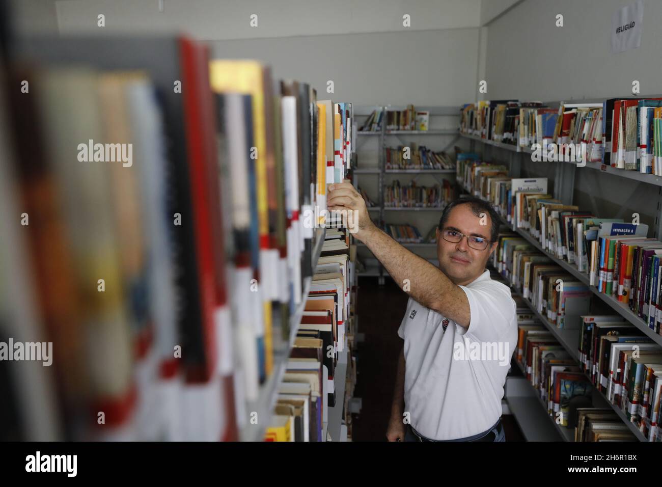 alagoinha, bahia, brazil - july 3, 2019: person is seen picking up a book from a shelf of a public library in the city of Alagoinhas. Stock Photo