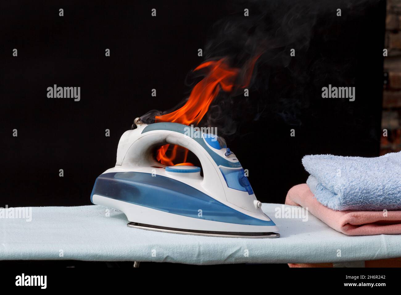 Iron on ironing board in flames fire, cause of fire Stock Photo Alamy