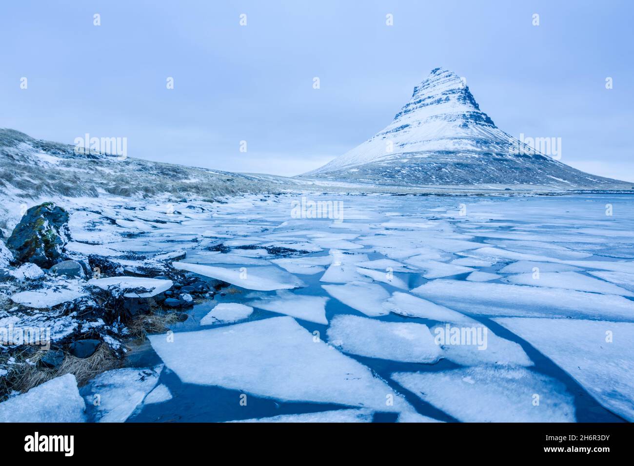 Moviing ice flioes below Kirkjufell mountain during winter on the Snæfellsnesnes peninsula in the Western part of Iceland Stock Photo