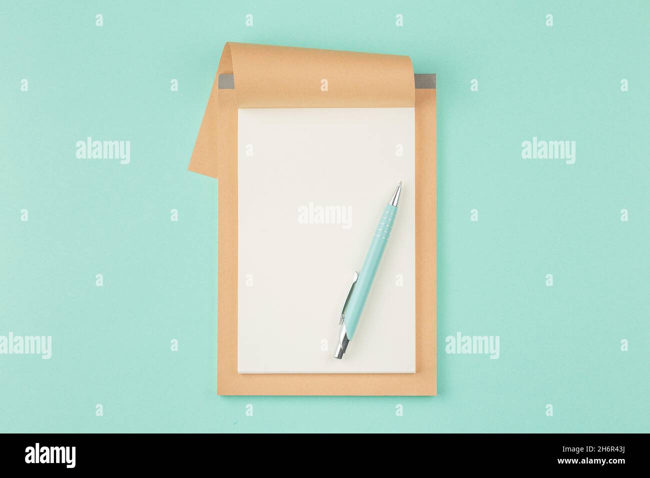 Open craft notepad on cyan background Stock Photo