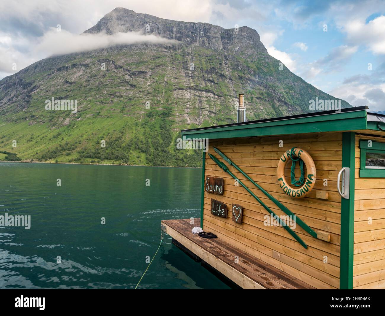 Floating sauna, marina of village Urke at the Hjorundfjord, mt. Stalbergneset in the back, Norway Stock Photo
