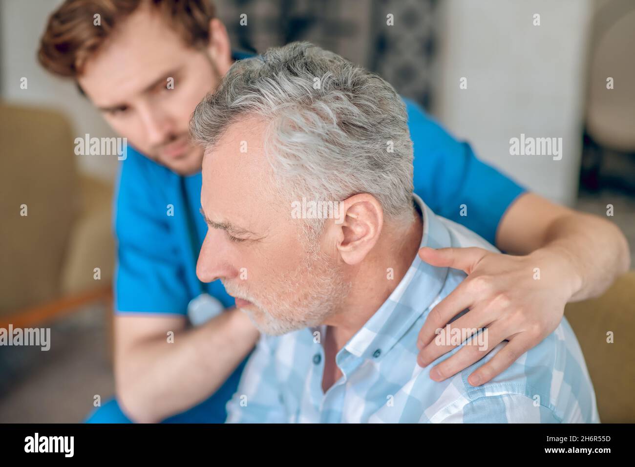 Attentive healthcare professional taking care of his patient Stock Photo