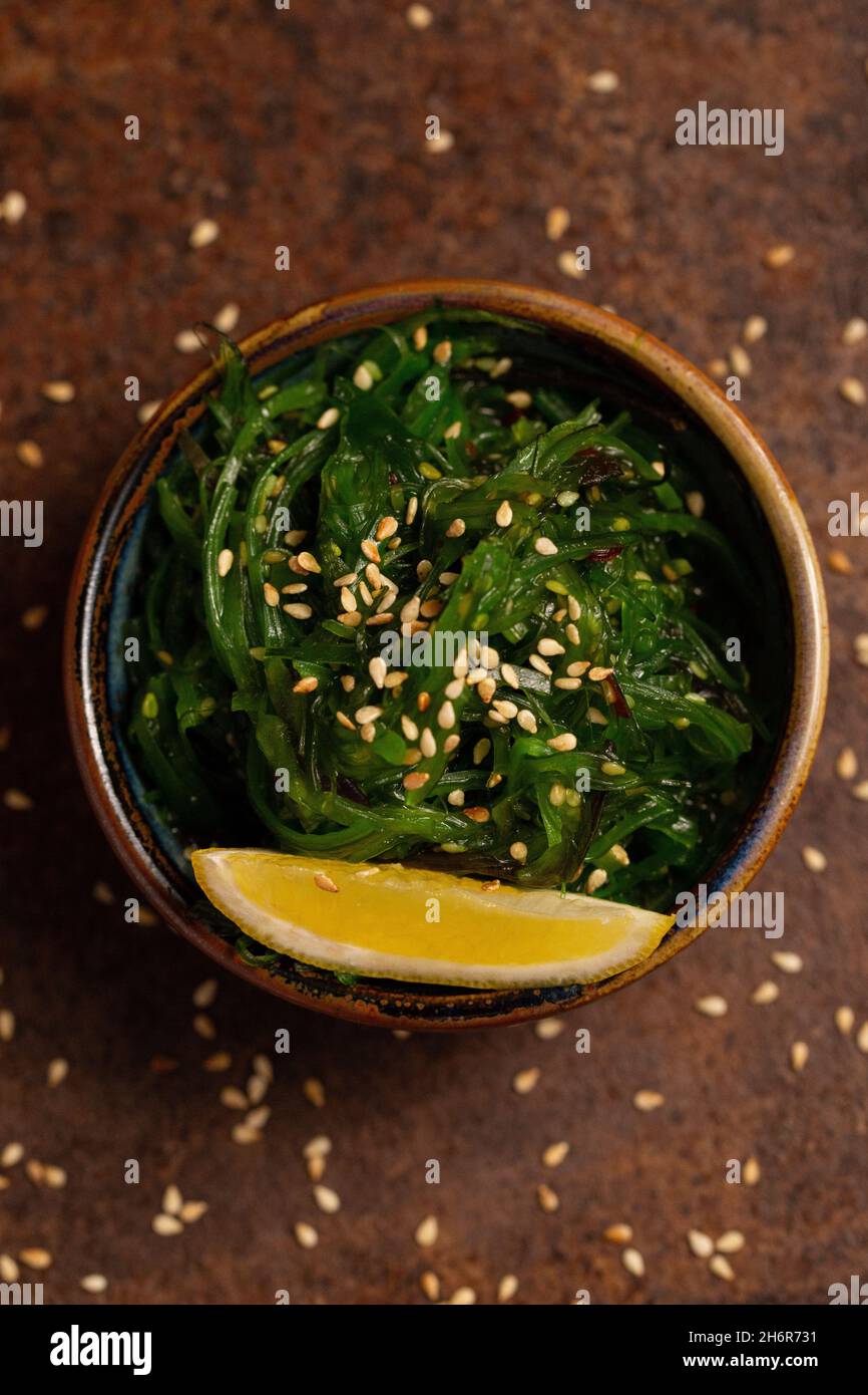 Wakame Salad in Bowl with Peace of Lemon. Asia cuisine. Healthy Food Stock Photo