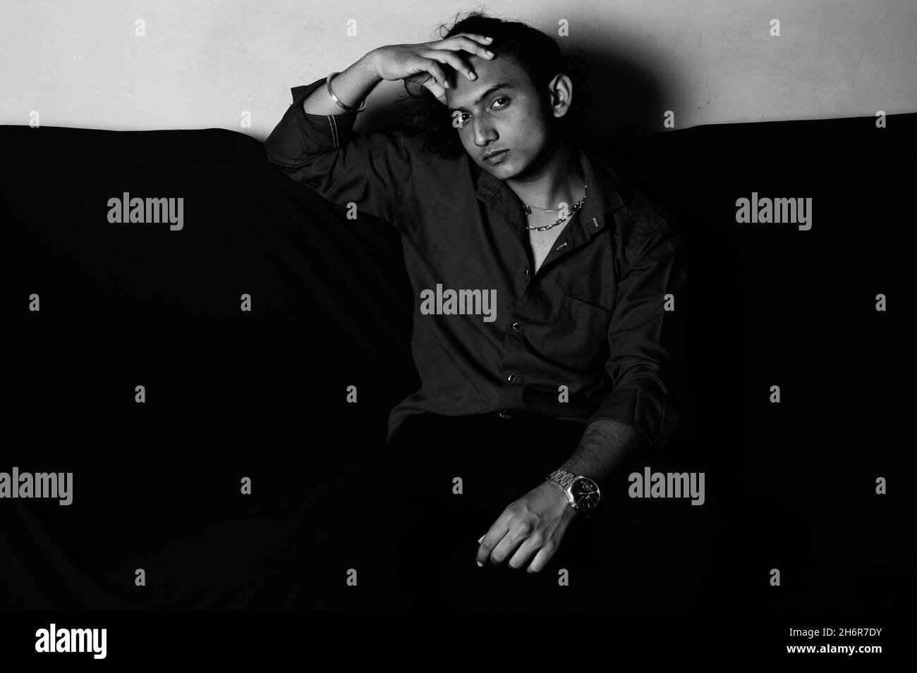 Grayscale of a South Asian man from India in sofa Stock Photo