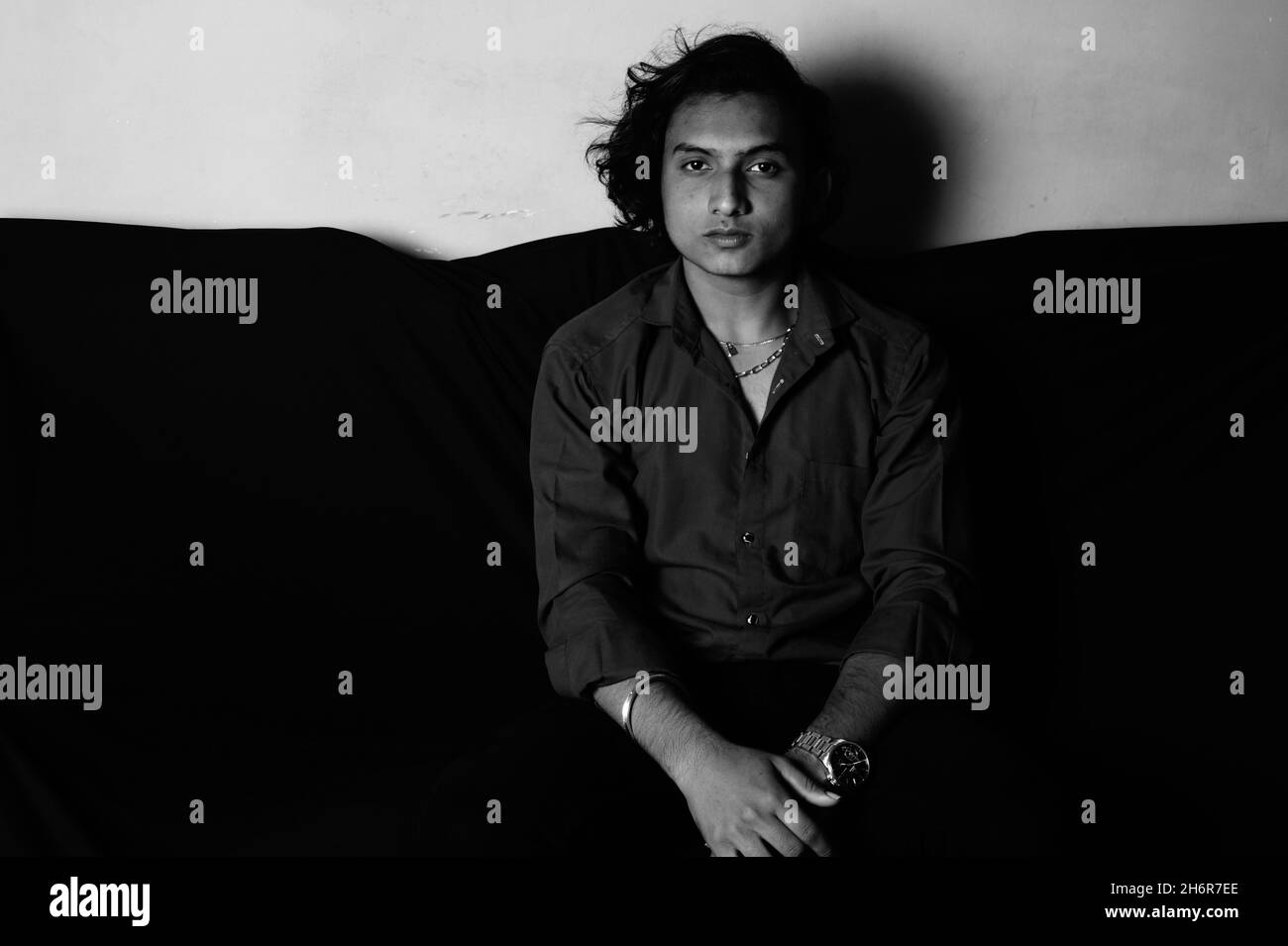 Grayscale of a South Asian man from India in sofa Stock Photo