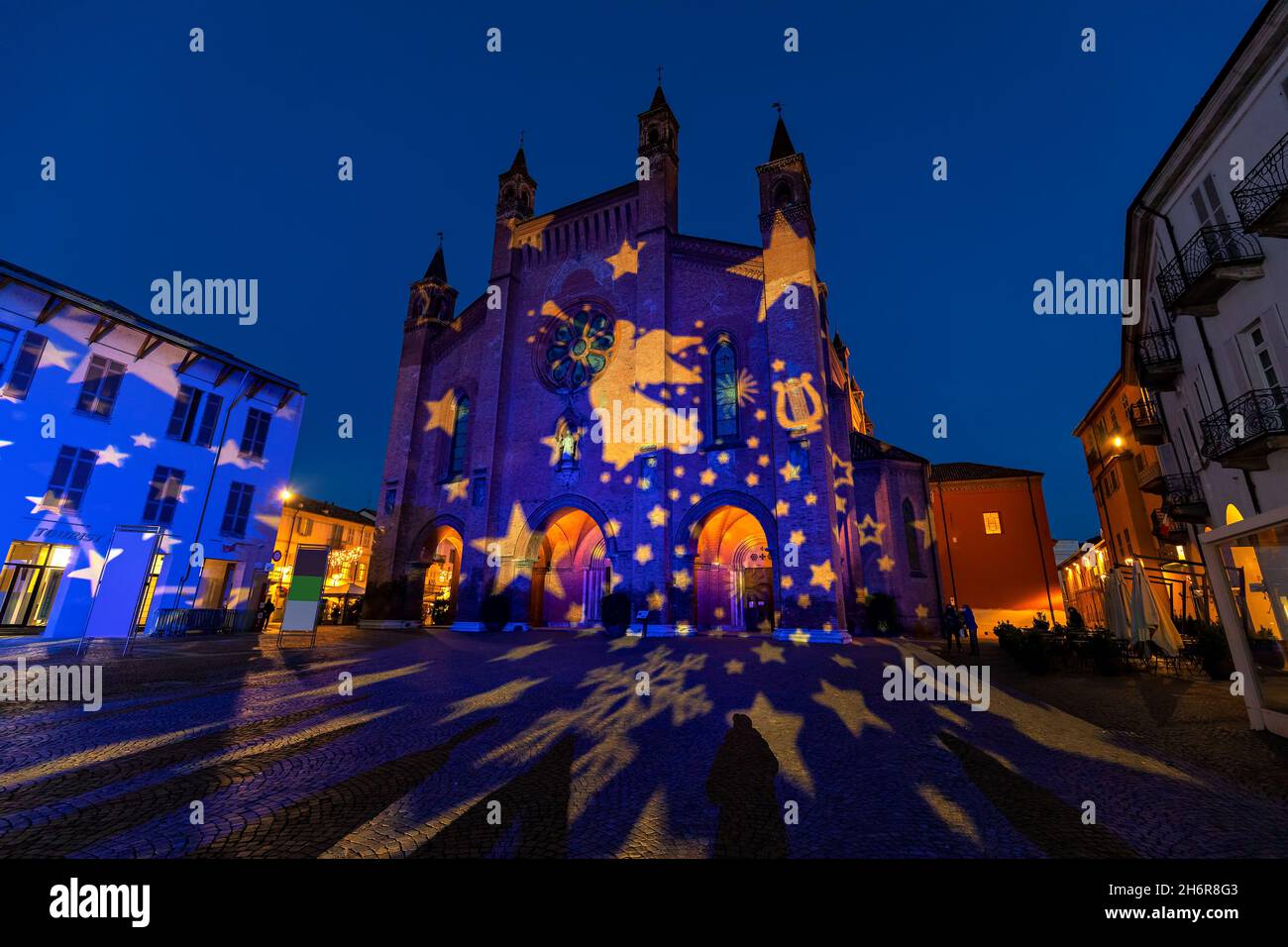 San Lorenzo cathedral illuminated for Christmas holidays in the evening on cobblestone square in old town of Alba, Piedmont, Northern Italy. Stock Photo