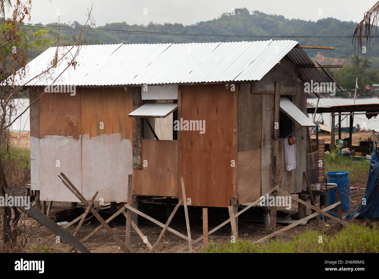 Kota Kinabalu, Malaysia - March 23, 2019: Poor wooden house stands on the coast of Mengkabong River Stock Photo