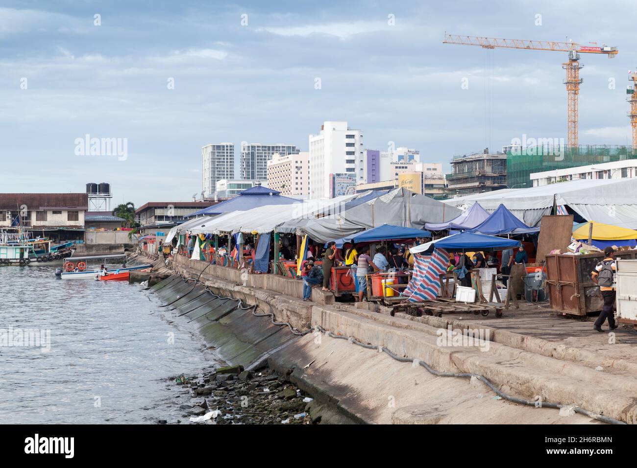 Kota Kinabalu, Malaysia - March 23, 2019: Seaside view of the KK Fish Market on a sunny day, ordinary people visit the marketplace Stock Photo