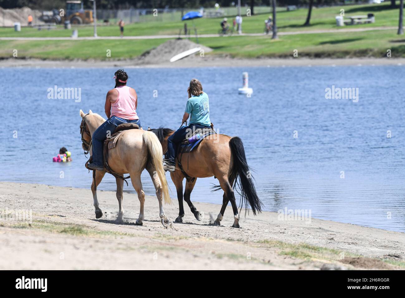 Riding horses along the shore of Fiesta Island in San Diego's Mission Bay Park. Stock Photo