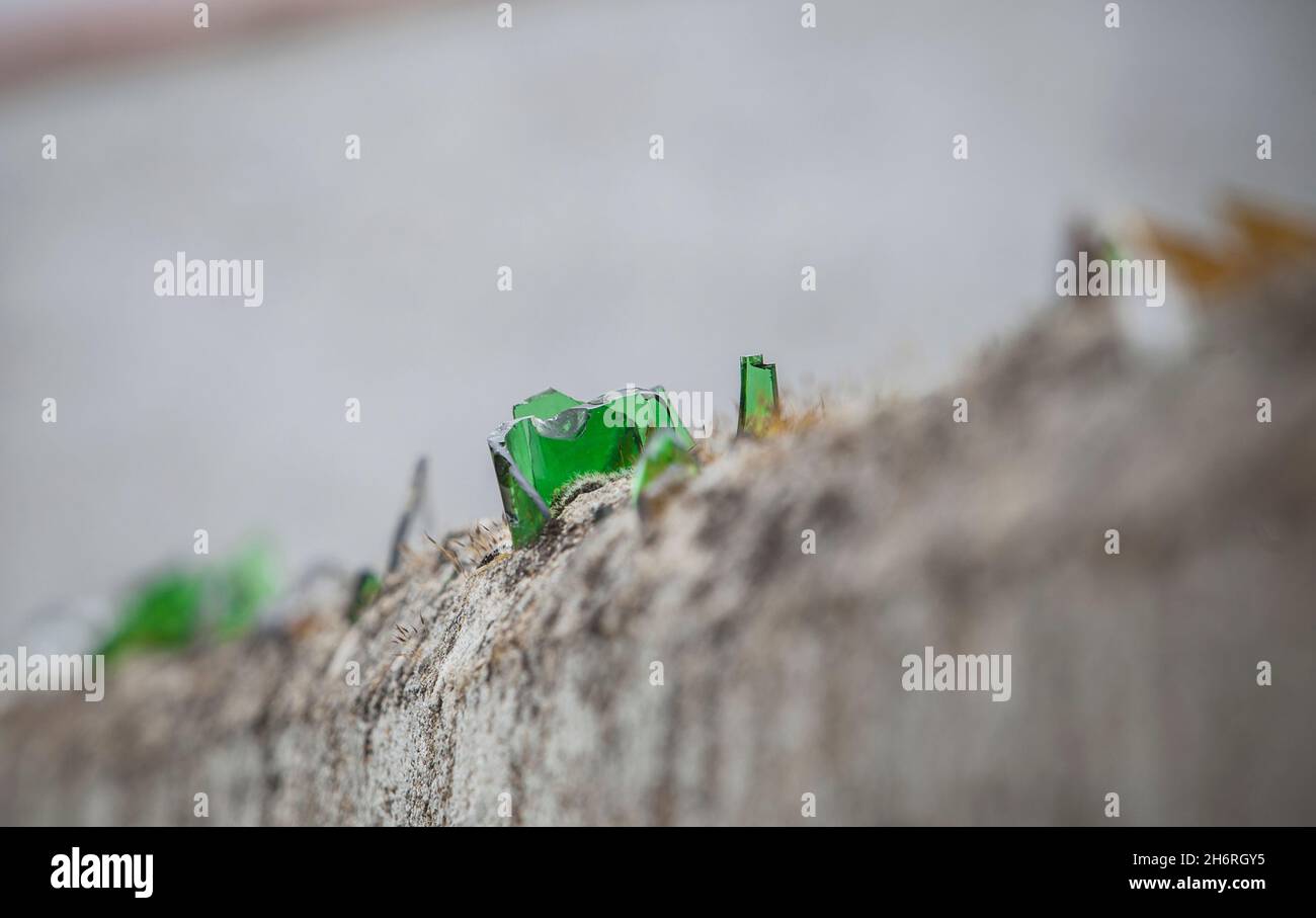 Wall top covered with broken glass. Sharp pieces inlaid on mortar Stock Photo