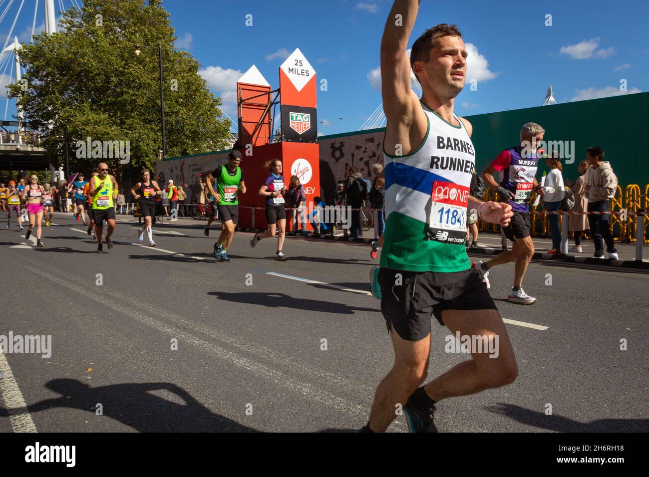 Man running with raised arm, Virgin Money London Marathon 2021 at the 25 mile point, Victoria Embankment. Stock Photo