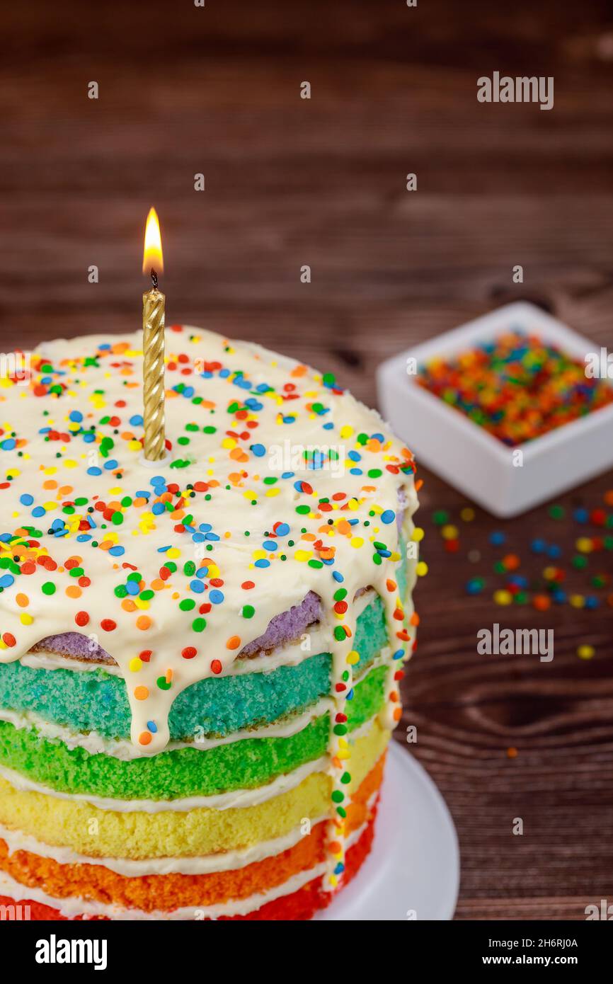Birthday cake with burning candle and sugar sprinkles Stock Photo - Alamy