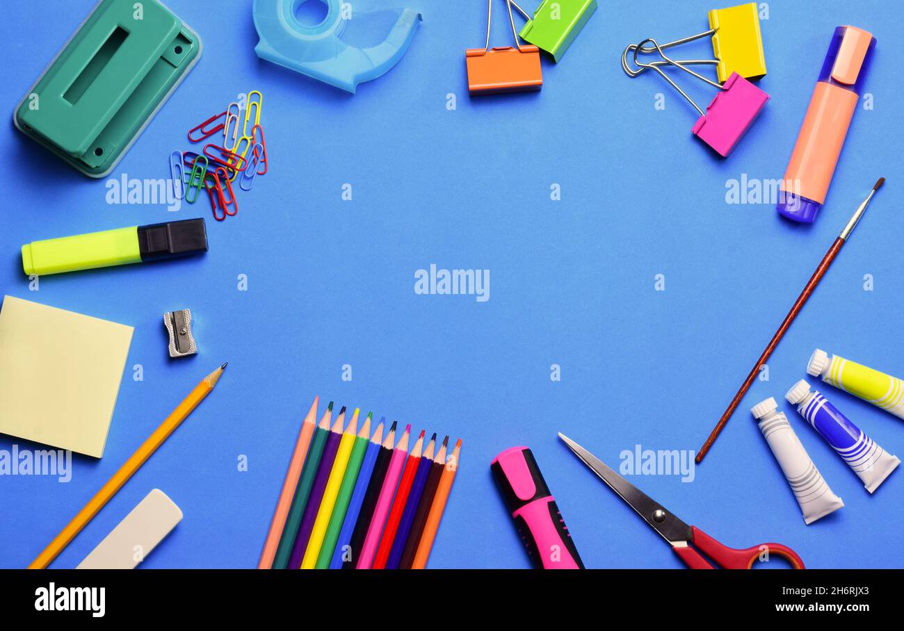 Top view of various school supplies on a blue surface - copy space Stock Photo