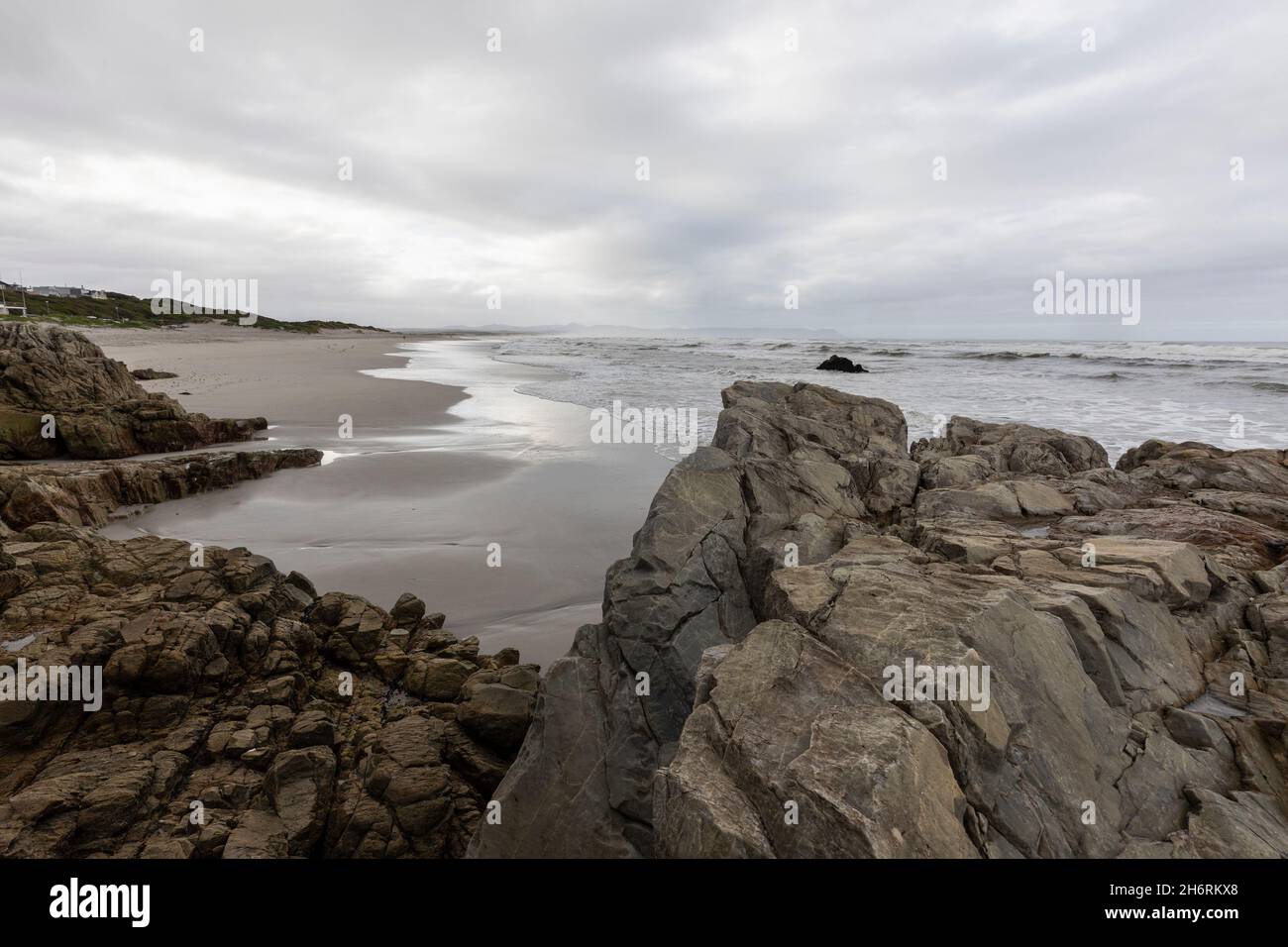 The jagged rocks and coastline of the Atlantic coast at Grotto Beach, a wide beach near Hermanus. Stock Photo