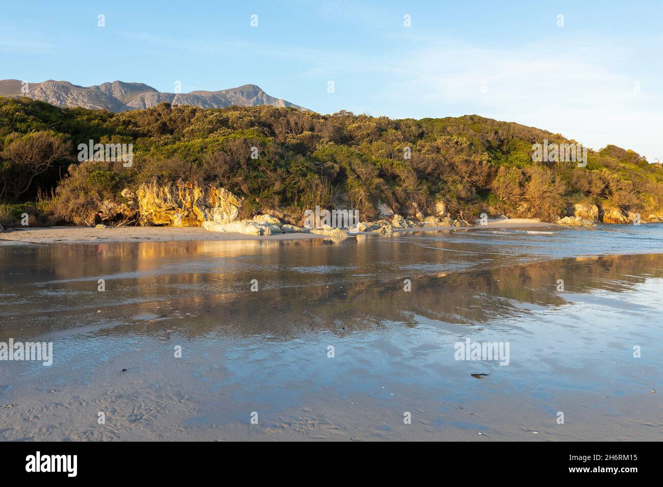 Woodland and mountains scenery, a small sheltered sandy beach on the Atlantic shore. Stock Photo