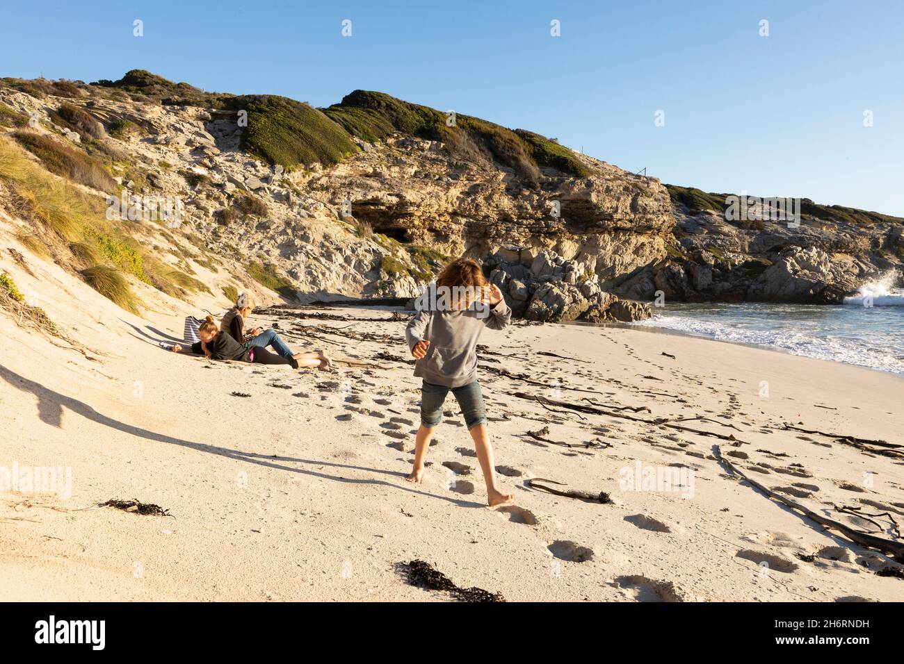 Family on a sandy beach, boy walking through soft sand Stock Photo
