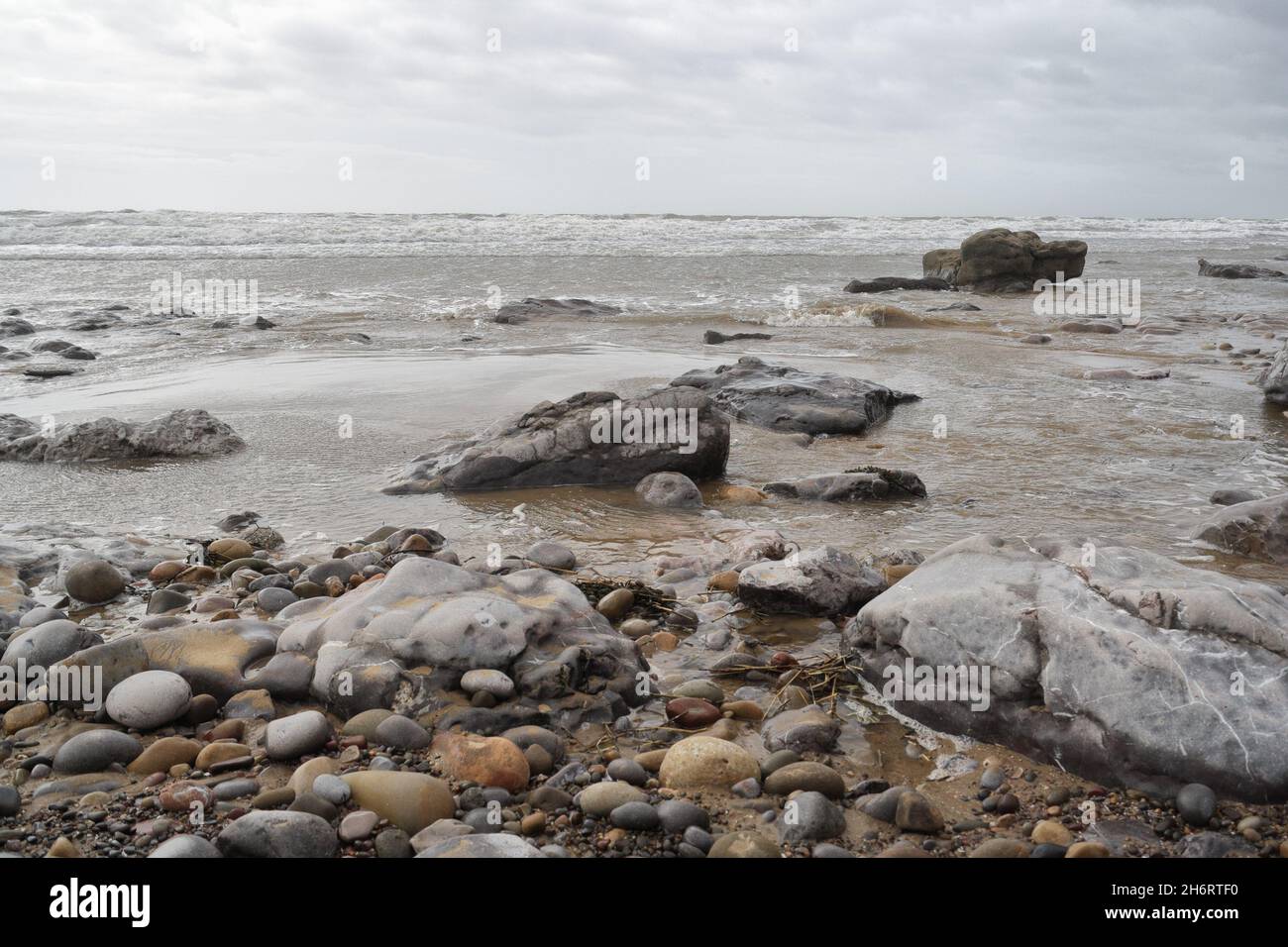 The shoreline at Porthcawl in Wales, Rocks and Pebbles Sea, Welsh coast, British coastline low angle seascape Stock Photo