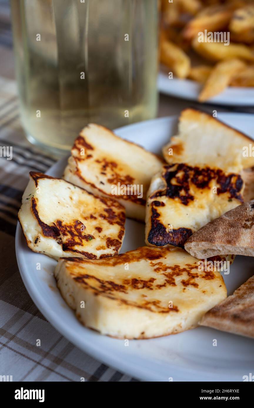 Traditional roasted or grilled halloumi cheese from Cyprus served hot with flat greek bread Stock Photo