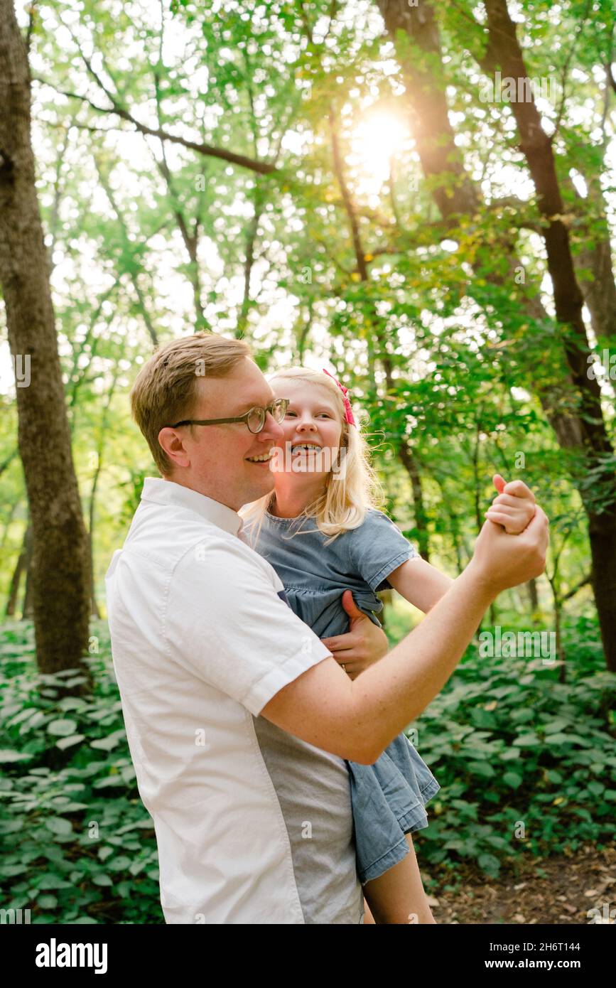 Portrait of a father and daughter dancing together in the forest Stock Photo