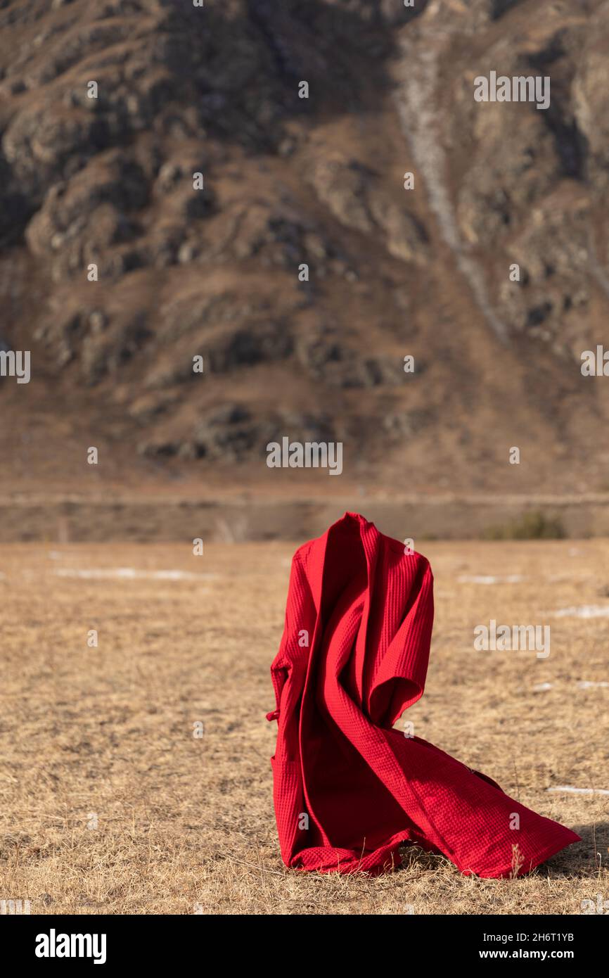 Flying red bathrobe on the background of the mountains Stock Photo