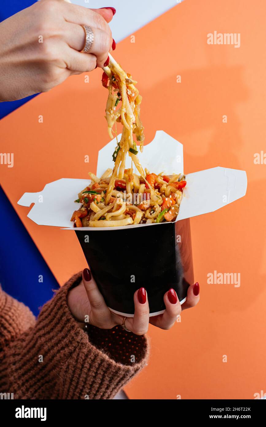 chinese rice noodles with chicken and vegetables in a takeaway box