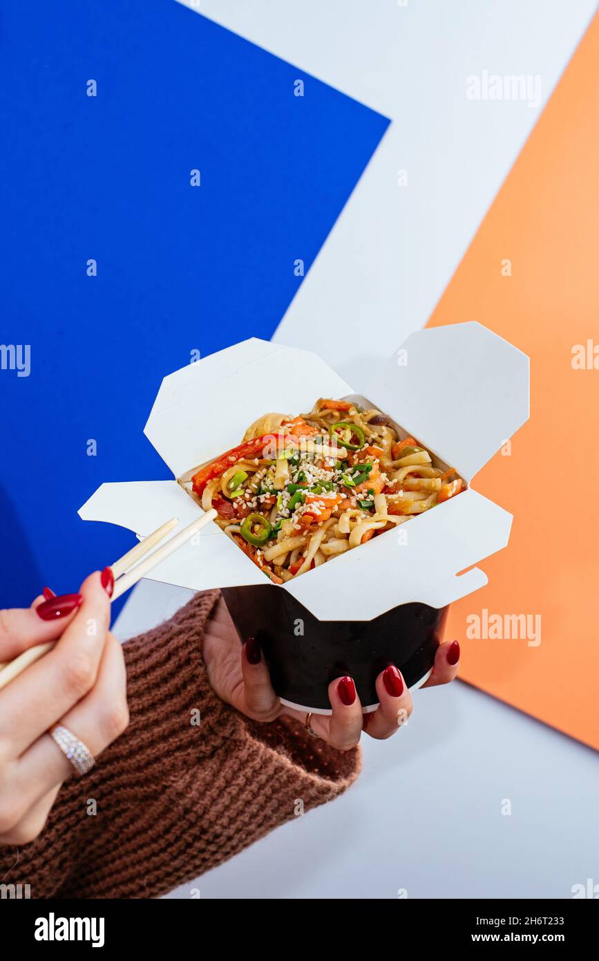 chinese rice noodles with chicken and vegetables in a takeaway box