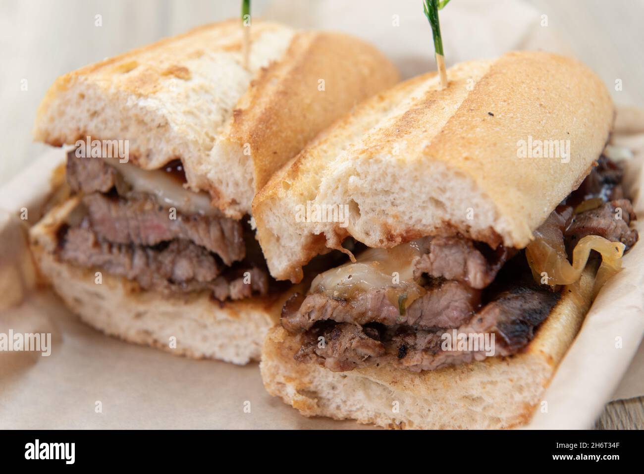 Two halves of a cut tri tip steak sandwich seasoned and arranged on a