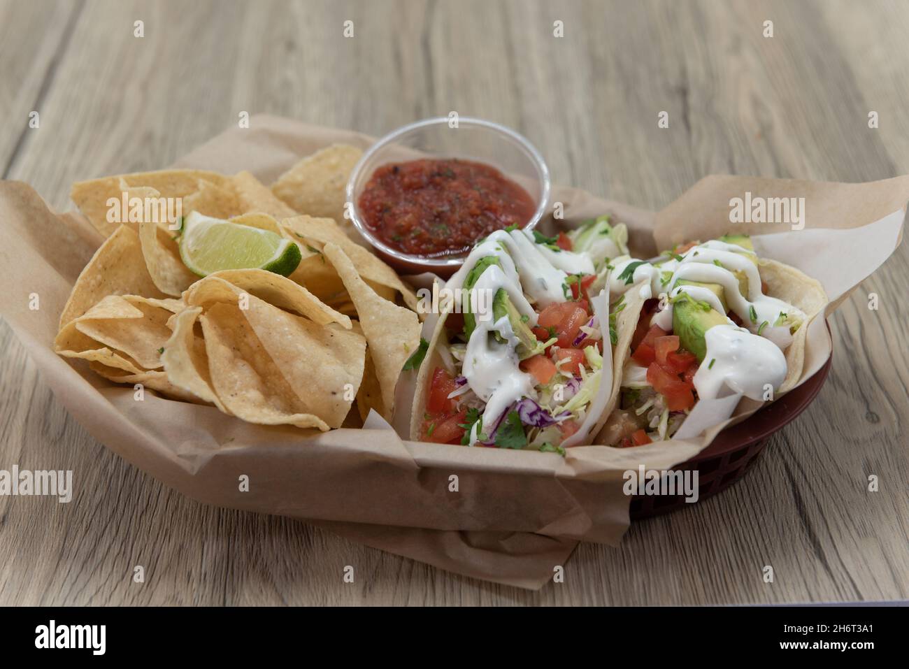 Hearty basket full of chips and salsa to eat with three fish tacos