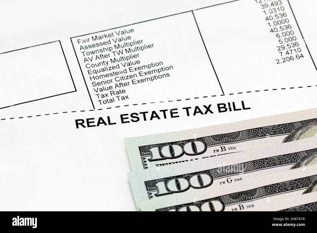 Real estate property tax bill with 100 dollar bills. school funding, taxes, debt, and local government funding concept Stock Photo