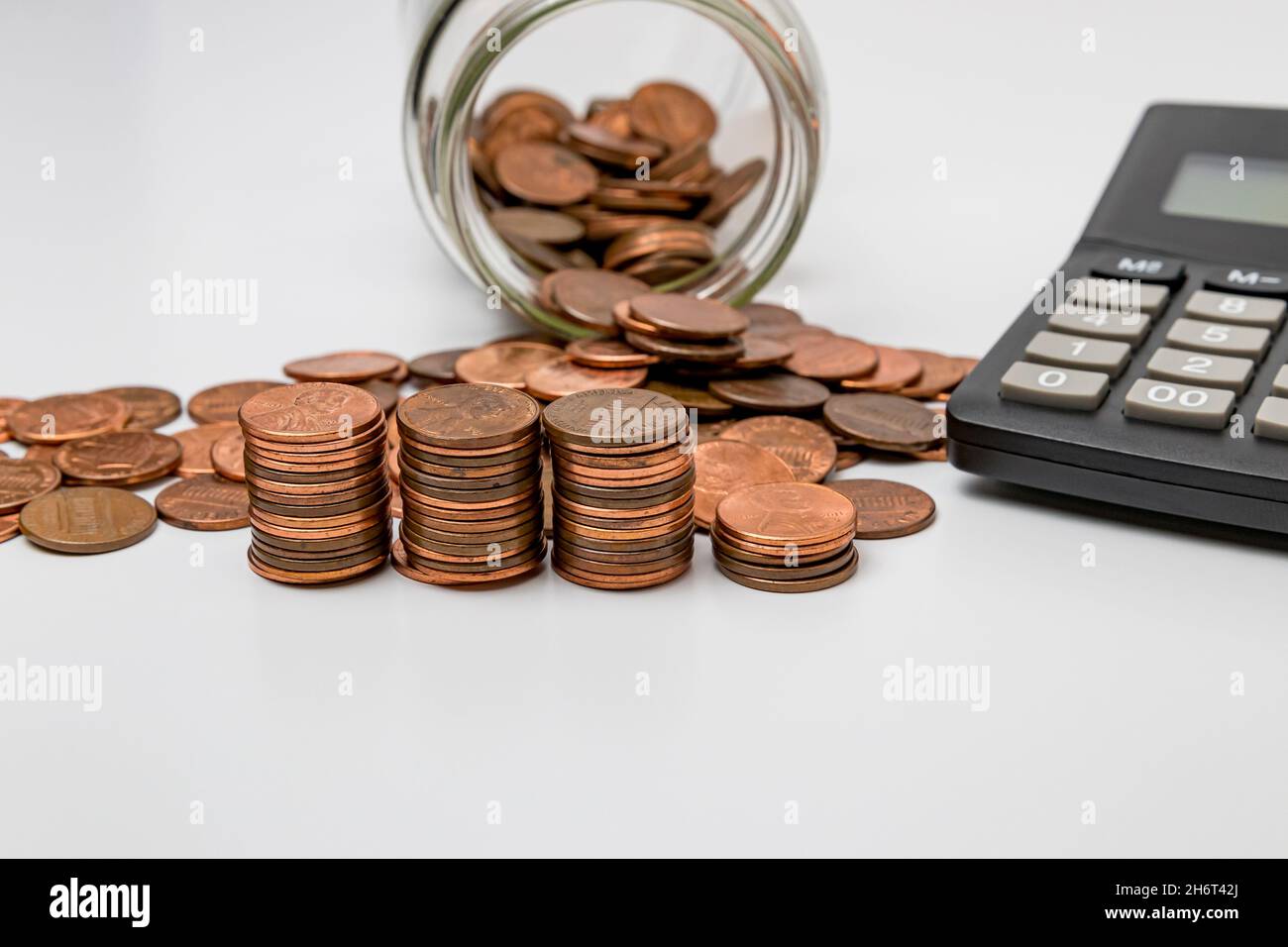 Spare change coin jar with stacks of pennies. Wealth, savings ...