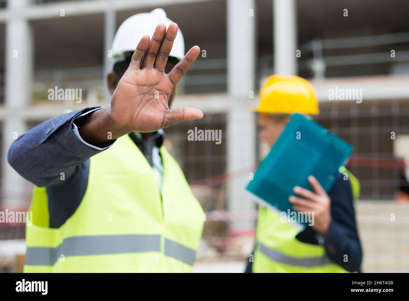 Head of construction site prohibits photographing and closes camera lens with hand Stock Photo