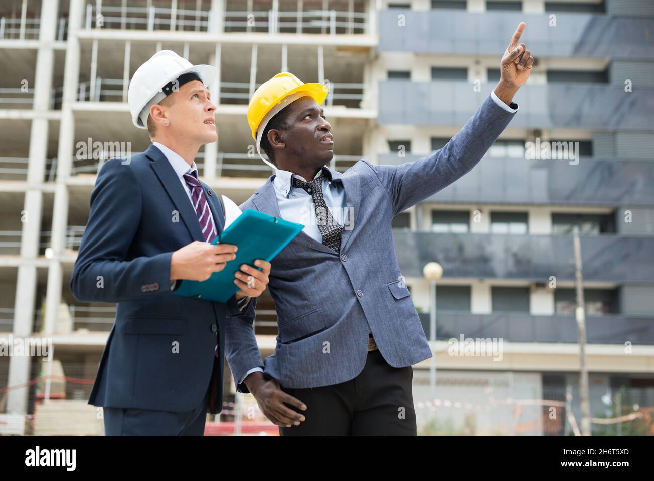 Architects talking about project documentation on construction plant Stock Photo