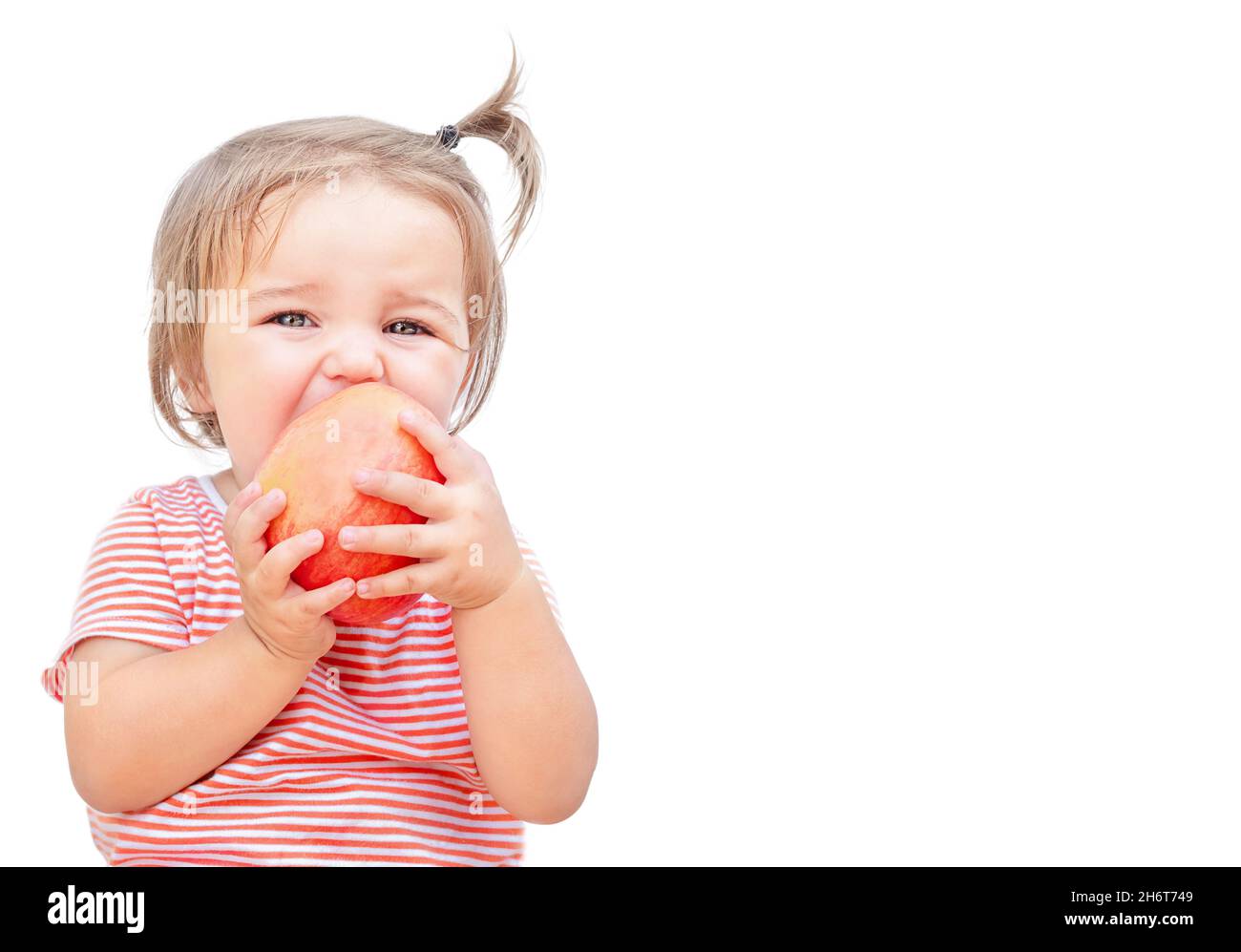 Child bites off an apple isolated on white background Stock Photo
