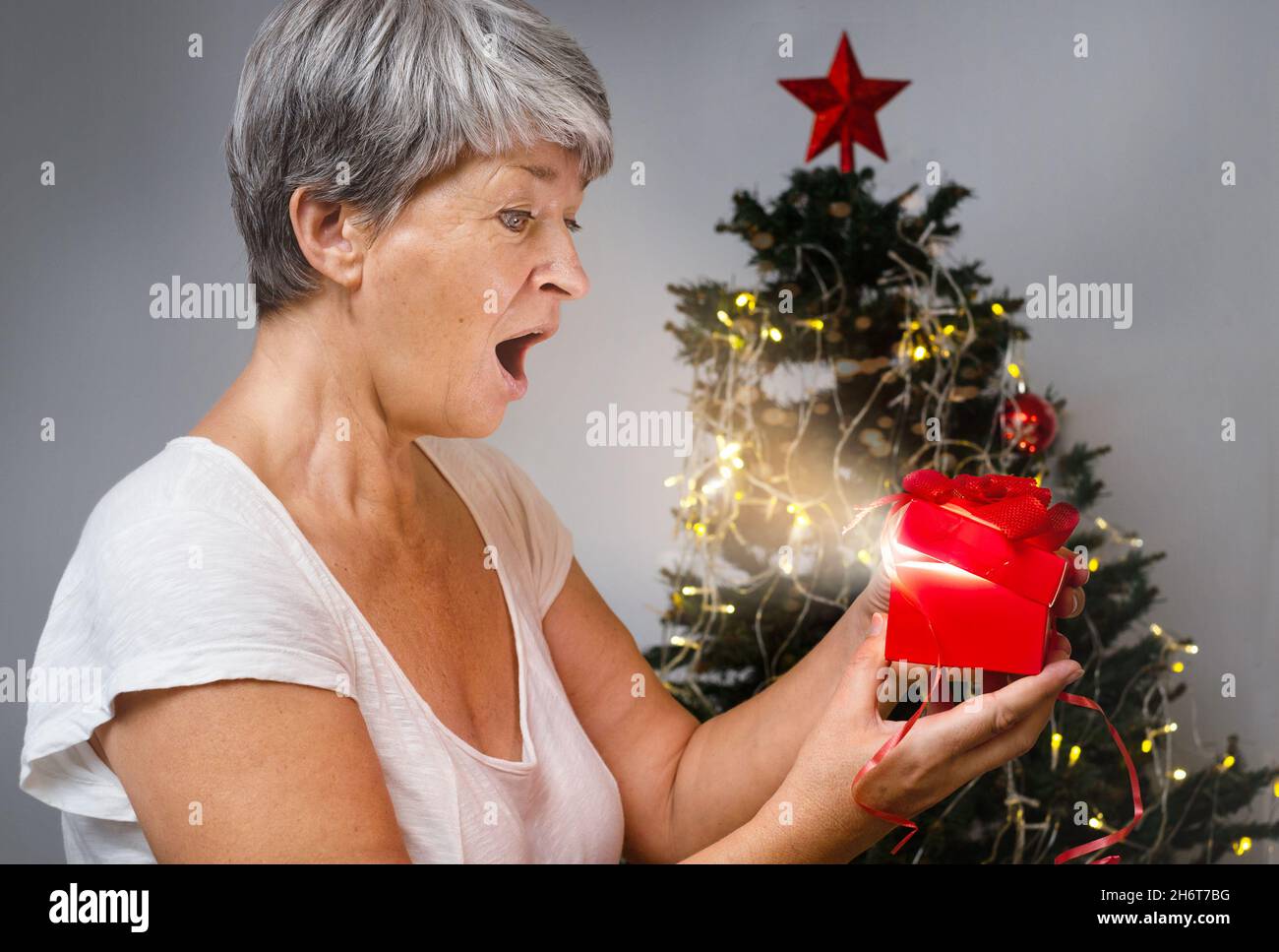 Mature woman christmas gift looking hi-res stock photography and images ...