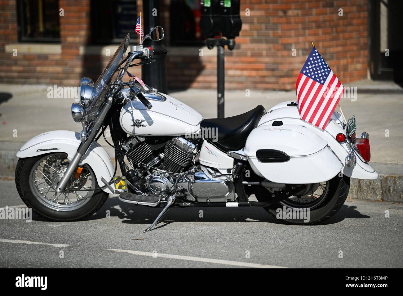 A Yamaha V-Star Classic sports a US flag on Main Street, Barre, VT, USA, on Veterans Day. Design clearly inspired by Harley-Davidson. Stock Photo