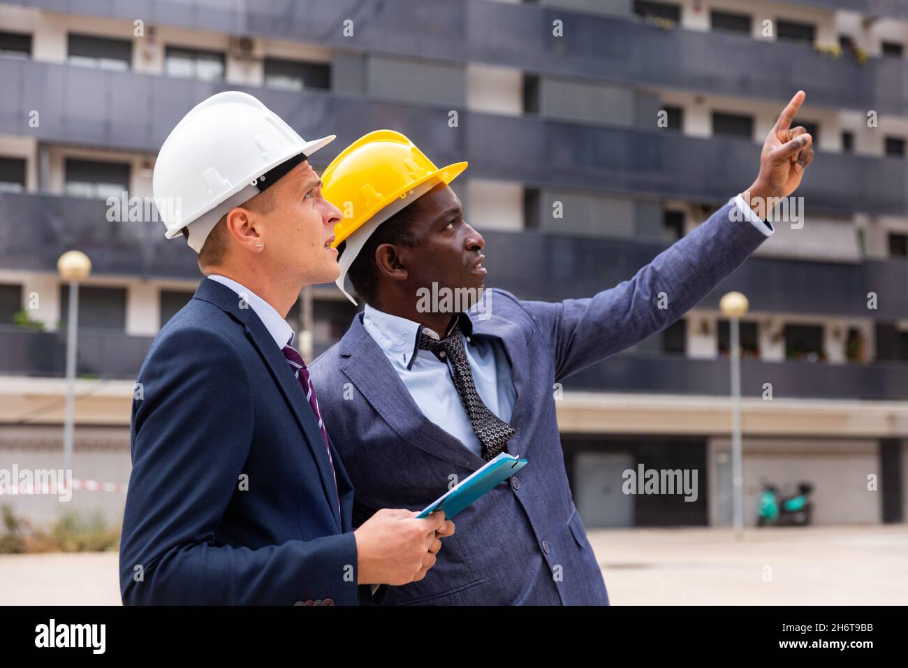 Architects talking about project documentation on construction plant Stock Photo