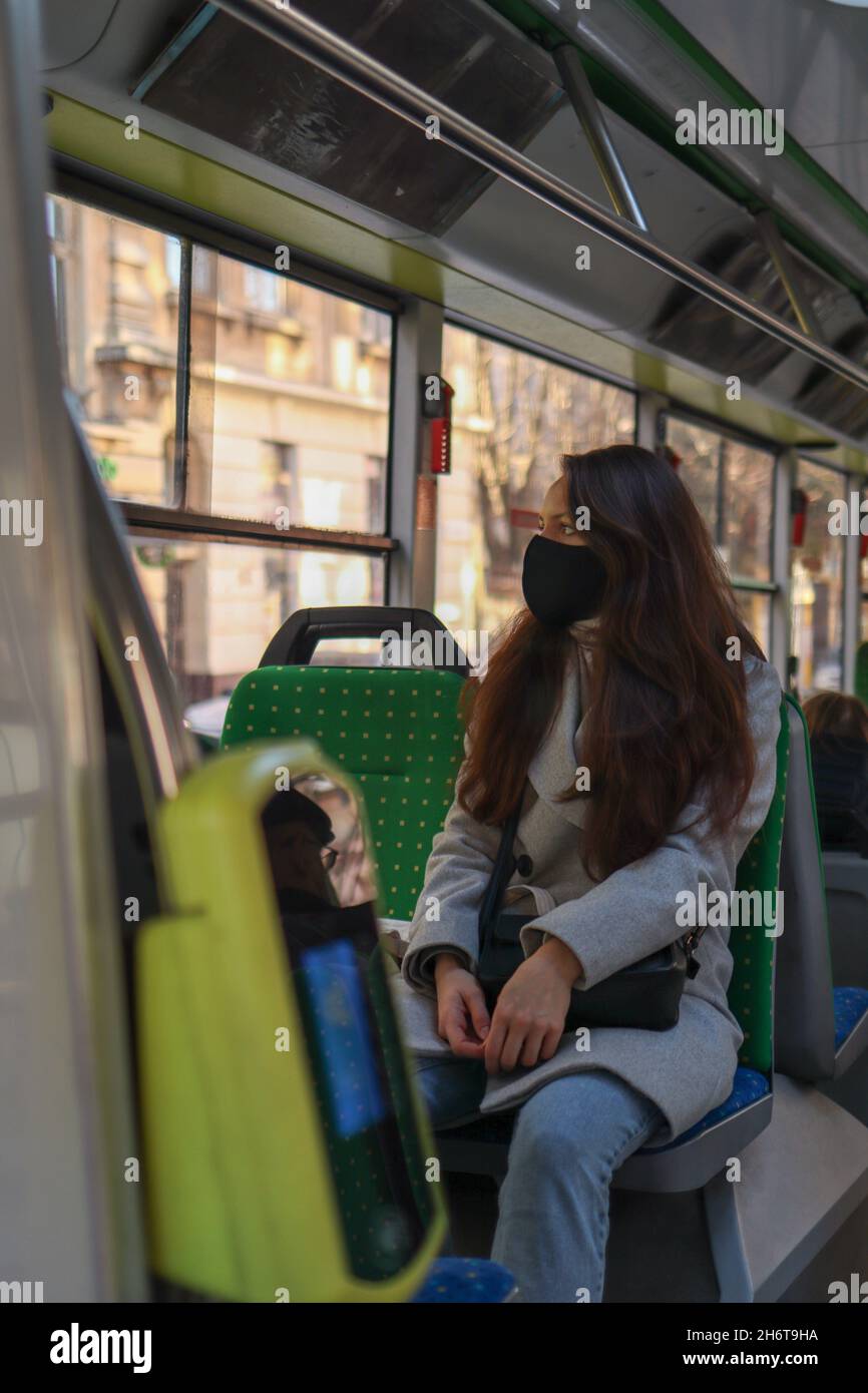Young woman is face mask is travelling by bus. Safety Precautions in