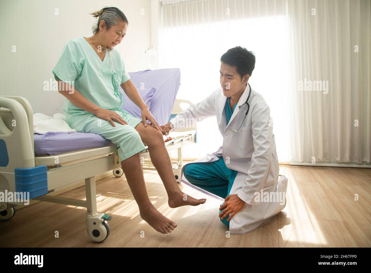 Asian male doctor examining the reaction of an Asian male patient. A