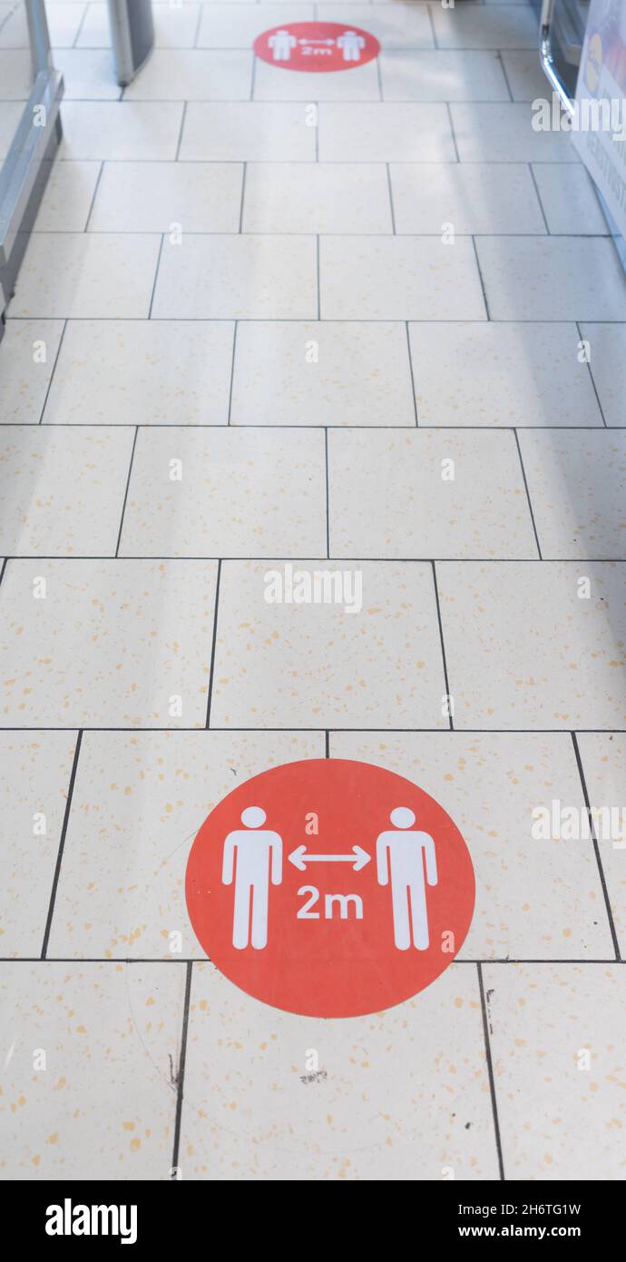 Covid19 Sign in Shopping Mall. Social Distancing Between People is Requiring in Public Places Stock Photo