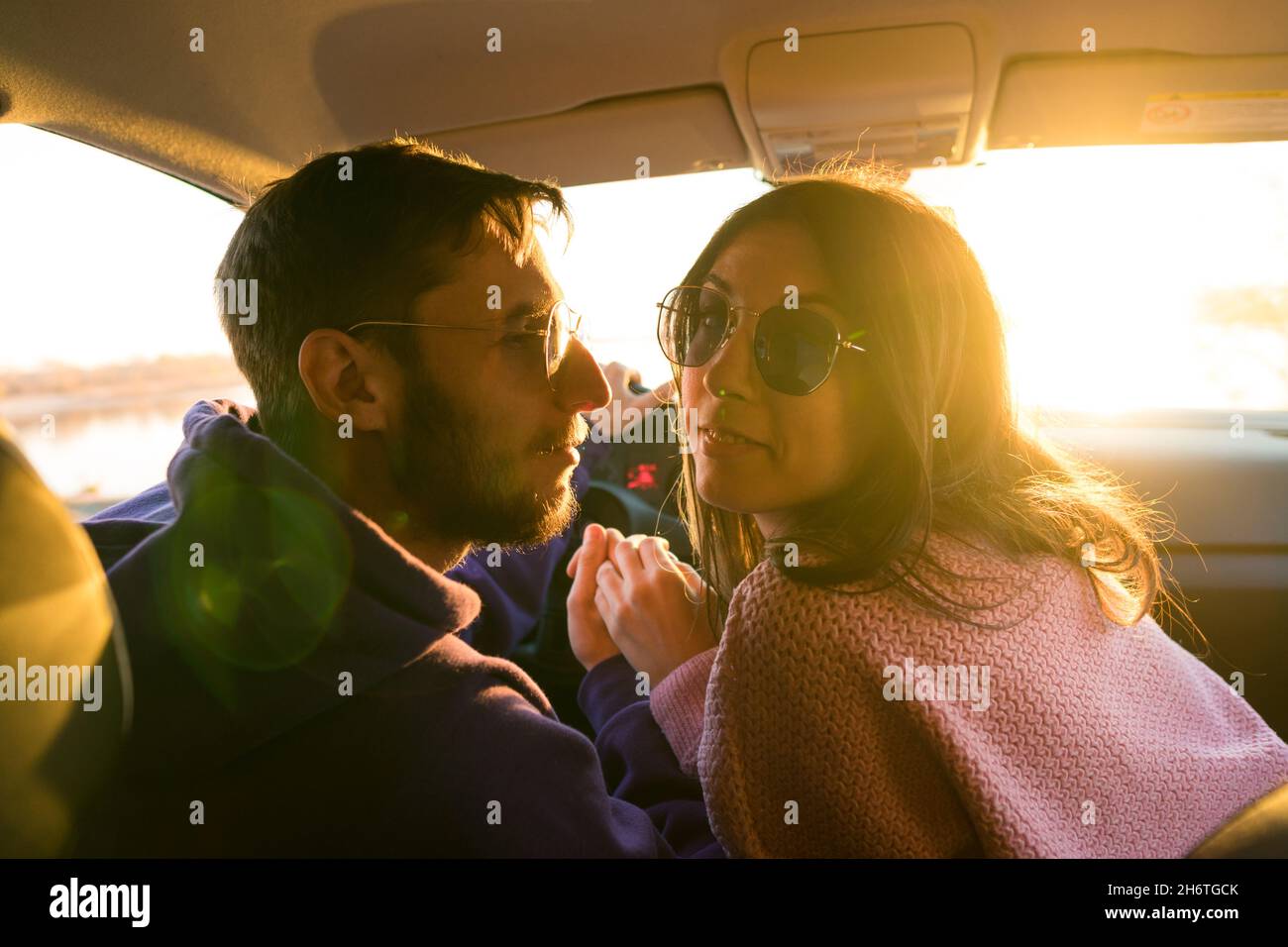 Authentic real people. Lovers casual style in car. Lifestyle Candid  portrait. Riding at sunny day. View from rear seat. Transportation, vehicle  concept. Romantic couple in Road trip Stock Photo - Alamy