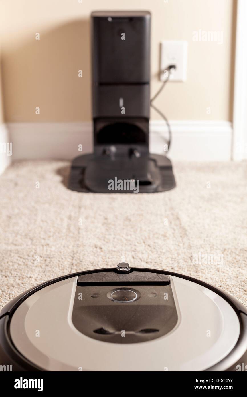 Close up generic image for robot vacuum cleaner. This unit is operating on carpetted floor and heading towards its base station for charging and empty Stock Photo