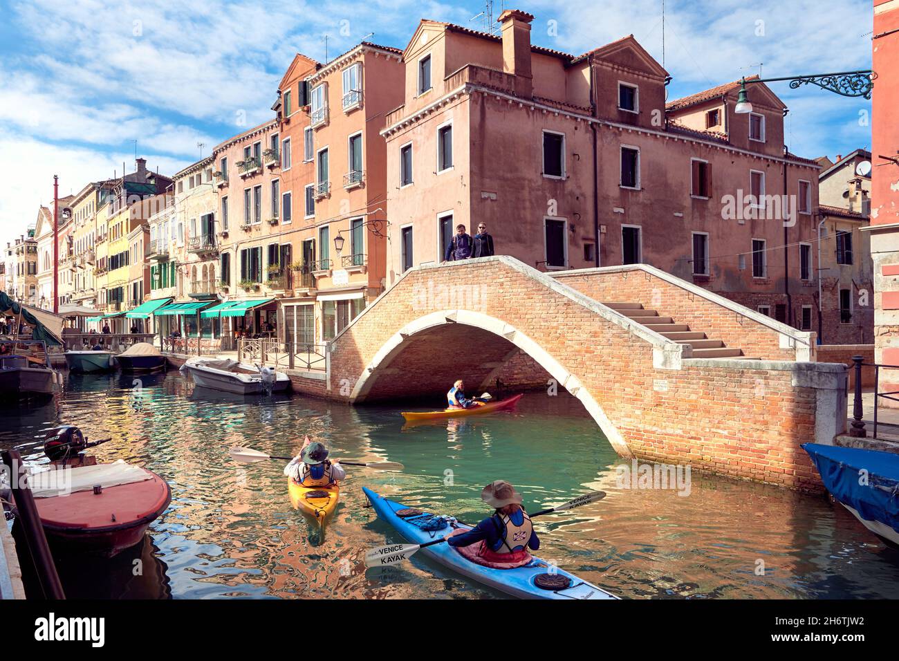 Kayak tour in Venice. Tourists, visitors in kayak boats go under