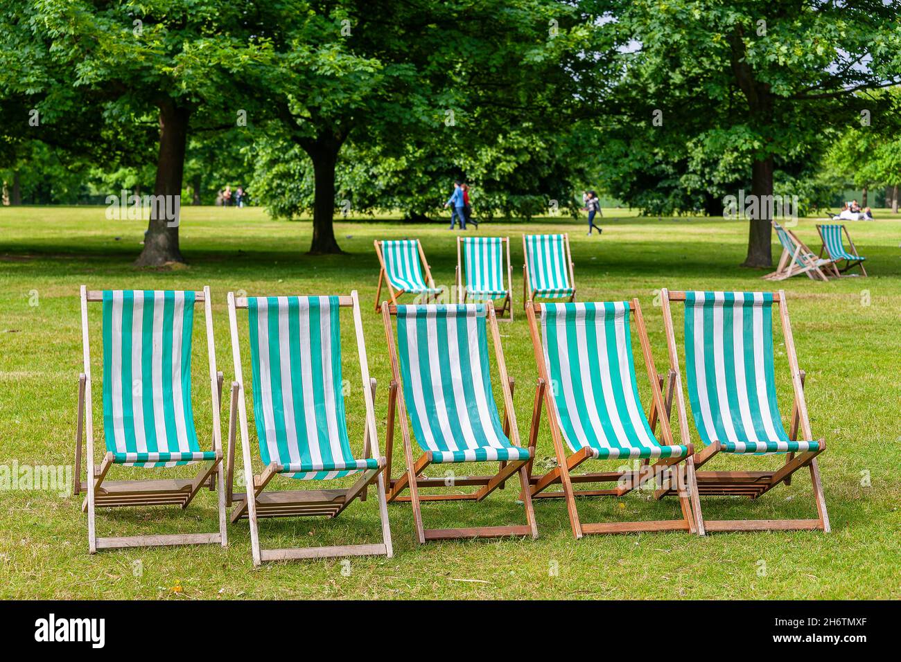 Traditional stripy deck chairs in green park. London, England Stock