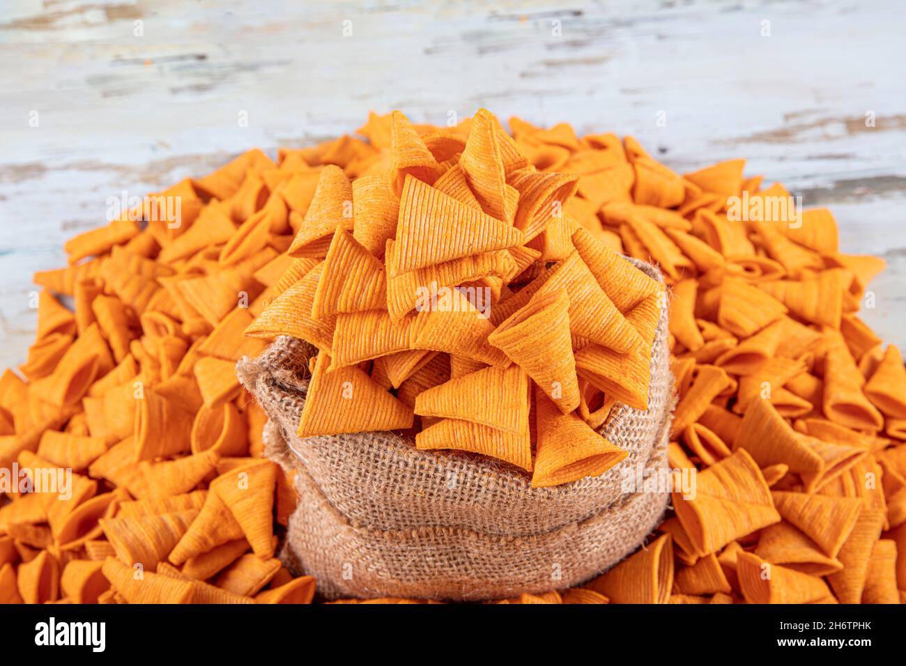 Portion of cone shaped snack tornado shaped crackers. Yellow spicy