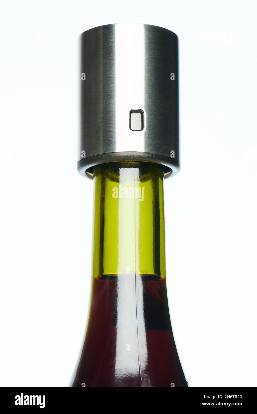 Closed red wine bottle with metal cork isolated on white studio