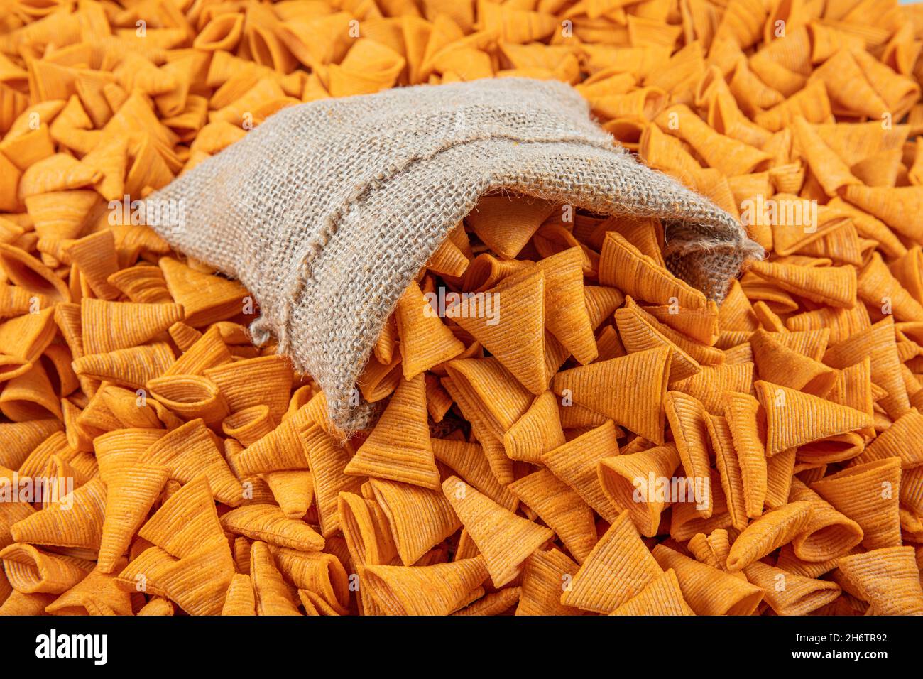 Portion of cone shaped snack tornado shaped crackers. Yellow spicy