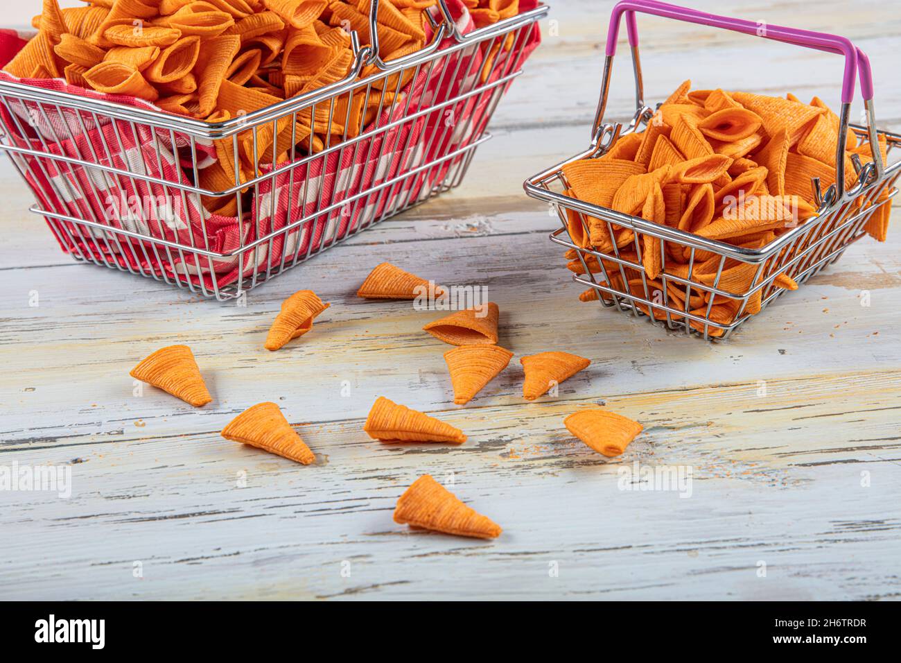Portion of cone shaped snack tornado shaped crackers. Yellow spicy